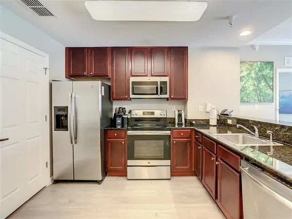 a kitchen with stainless steel appliances granite countertop a refrigerator stove and sink
