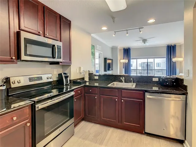 a kitchen with stainless steel appliances granite countertop a stove microwave and sink