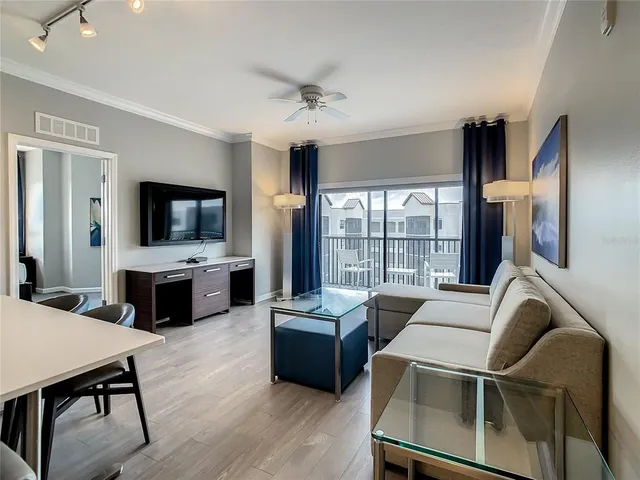 a living room with furniture flat screen tv and a large window