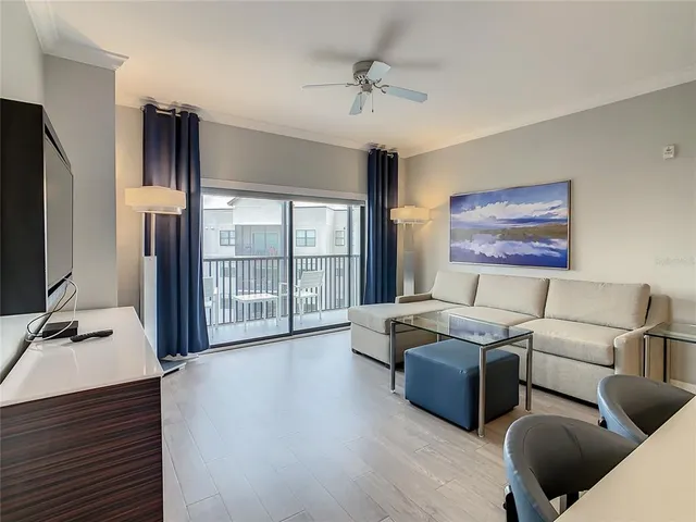 a living room with furniture flat screen tv and a floor to ceiling window