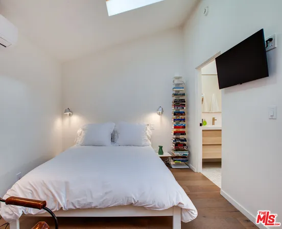 a bedroom with a bed and a flat screen tv