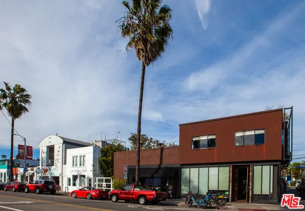 a front view of a building with palm trees