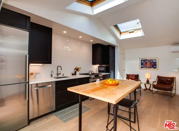 a view of a kitchen area with furniture and wooden floor