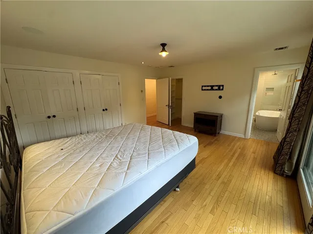 a spacious bedroom with a bed and a dresser in it