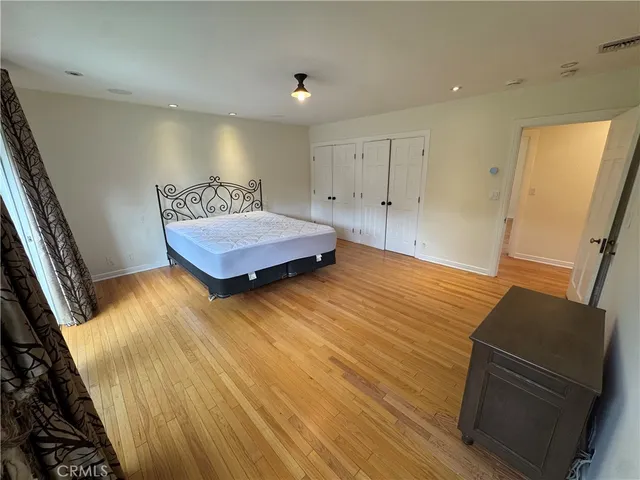 a bedroom with a bed and wooden floor
