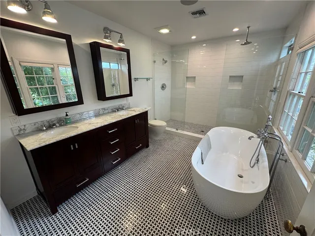 a bathroom with a double vanity sink a mirror and a bathtub