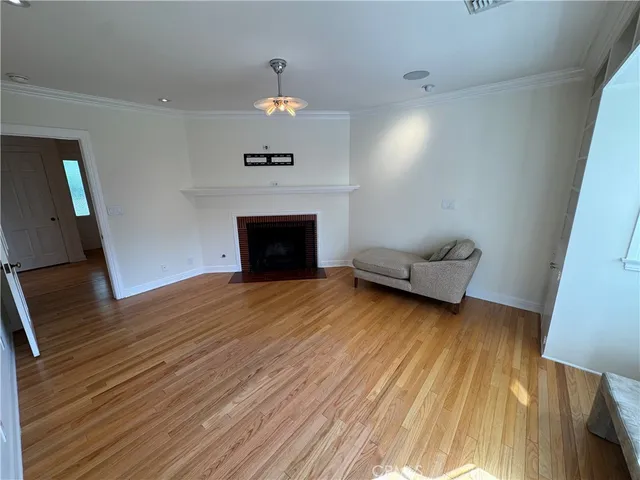an empty room with wooden floor and fireplace