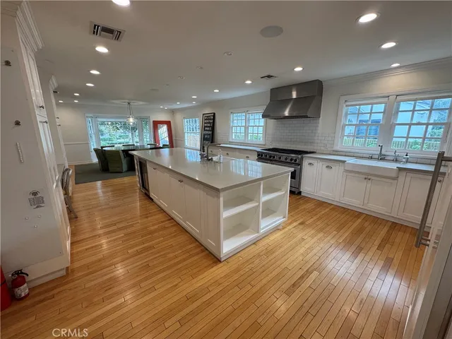 a large kitchen with stainless steel appliances granite countertop a large counter top a sink and a refrigerator