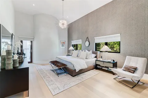 a spacious bedroom with a bed couch and a flat tv screen