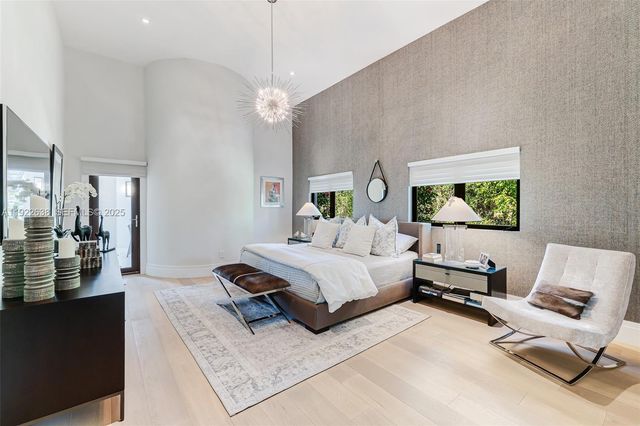 a spacious bedroom with a bed couch and a flat tv screen