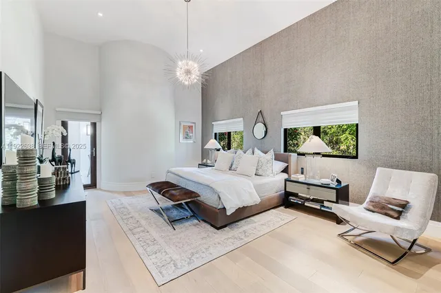 a spacious bedroom with a bed couch and a flat tv screen