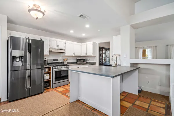 a kitchen with stainless steel appliances granite countertop a refrigerator sink and stove