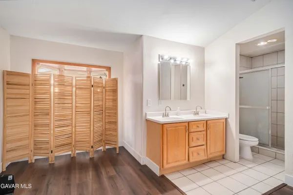 a bathroom with a double vanity sink toilet and shower