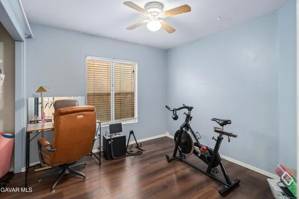 a room with gym equipment and wooden floor