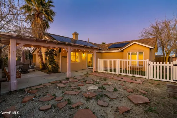 a view of a chair and table in backyard of the house