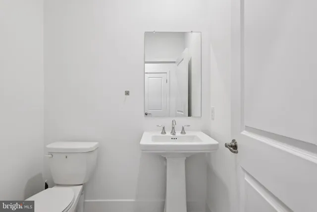 a bathroom with a sink mirror and toilet