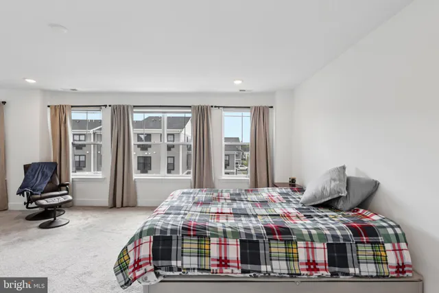 a bedroom with bed and a large window