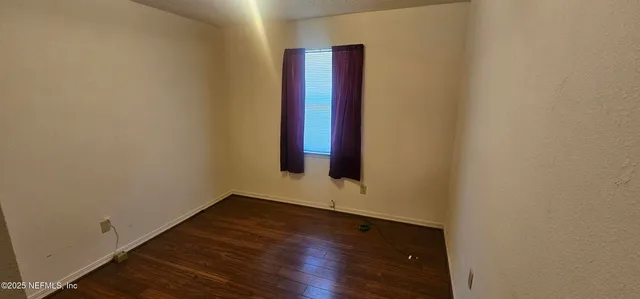 an empty room with wooden floor and closet