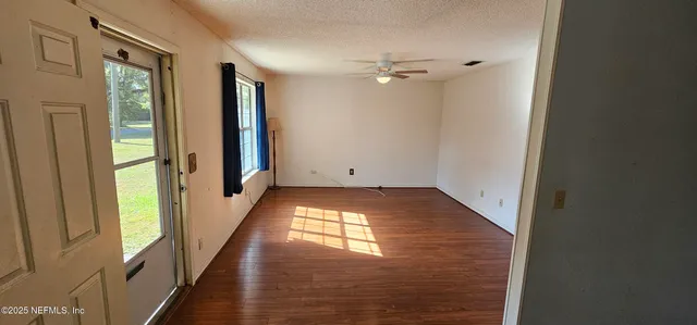 a view of a kitchen with a stove wooden cabinets and a refrigerator