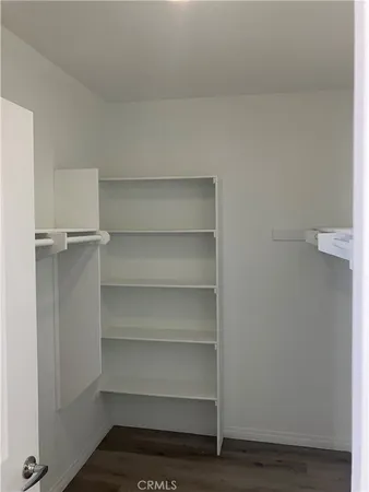 a view of walk in closet with empty racks