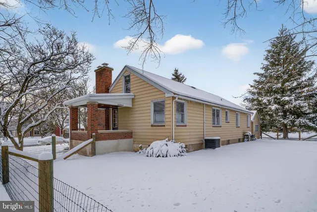 a front view of house with yard and trees in the background