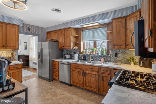 a kitchen with stainless steel appliances a refrigerator sink and stove