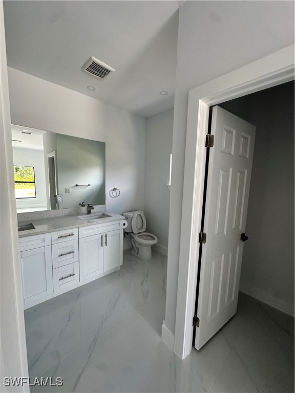 821 Bell Boulevard Lehigh Acres, FL 33974 - Photo 13 of 35 a large bathroom with a granite countertop sink mirror and a toilet