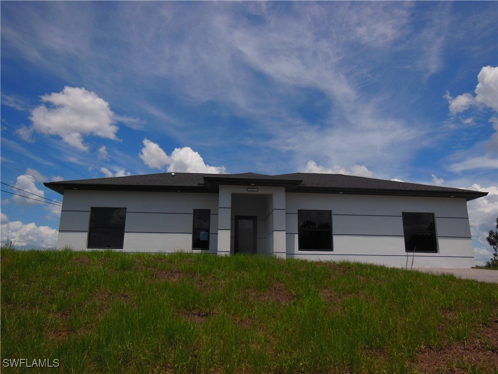 821 Bell Boulevard Lehigh Acres, FL 33974 - Photo 2 of 35 a house view with a garden space