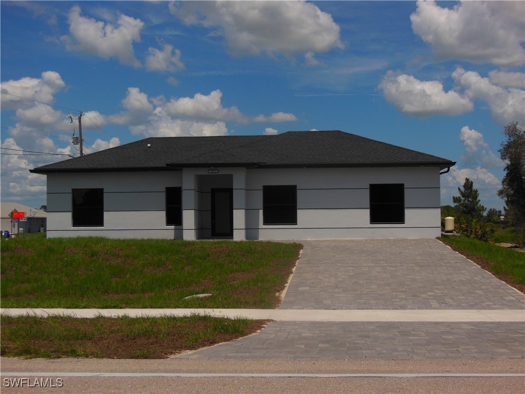 821 Bell Boulevard Lehigh Acres, FL 33974 - Photo 34 of 35 a front view of a house with a garden