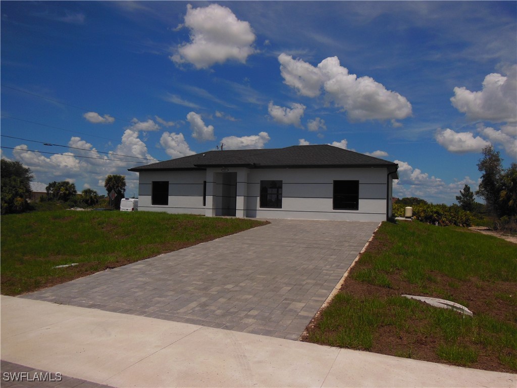 821 Bell Boulevard Lehigh Acres, FL 33974 - Photo 4 of 35 a front view of a house with a garden