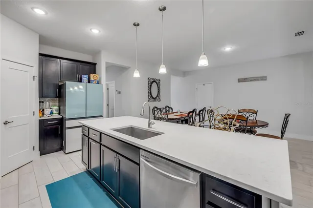 a kitchen with stainless steel appliances granite countertop a sink a stove and a refrigerator