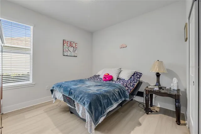 a living room with a bed and a dresser next to a window