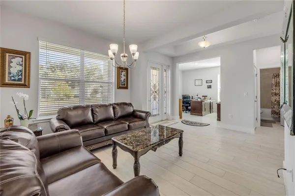 a living room with furniture a large window and a chandelier