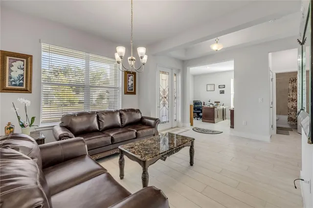 a living room with furniture a large window and a chandelier