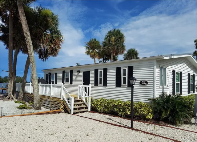 a front view of a house with a yard and potted plants