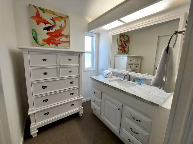 a bathroom with a granite countertop double vanity sink and mirror