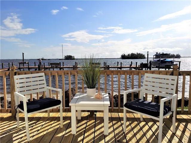 a view of a balcony with chairs and wooden floor