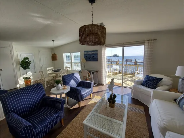 a living room with furniture a fireplace and a floor to ceiling window