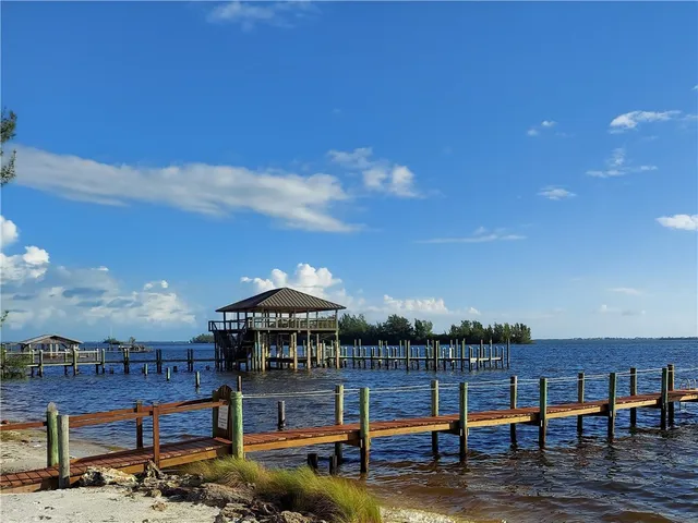 a view of swimming pool with lawn chairs under an umbrella