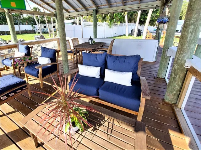 a view of a patio with table and chairs potted plants with wooden floor and fence