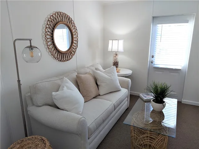 a living room with furniture a window and a potted plant
