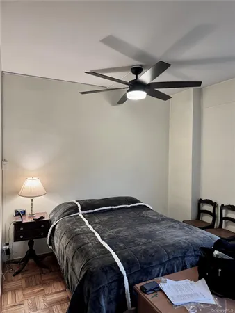 a bedroom with a bed and a lamp on the dresser