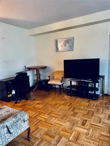 a living room with furniture a rug and a dining table