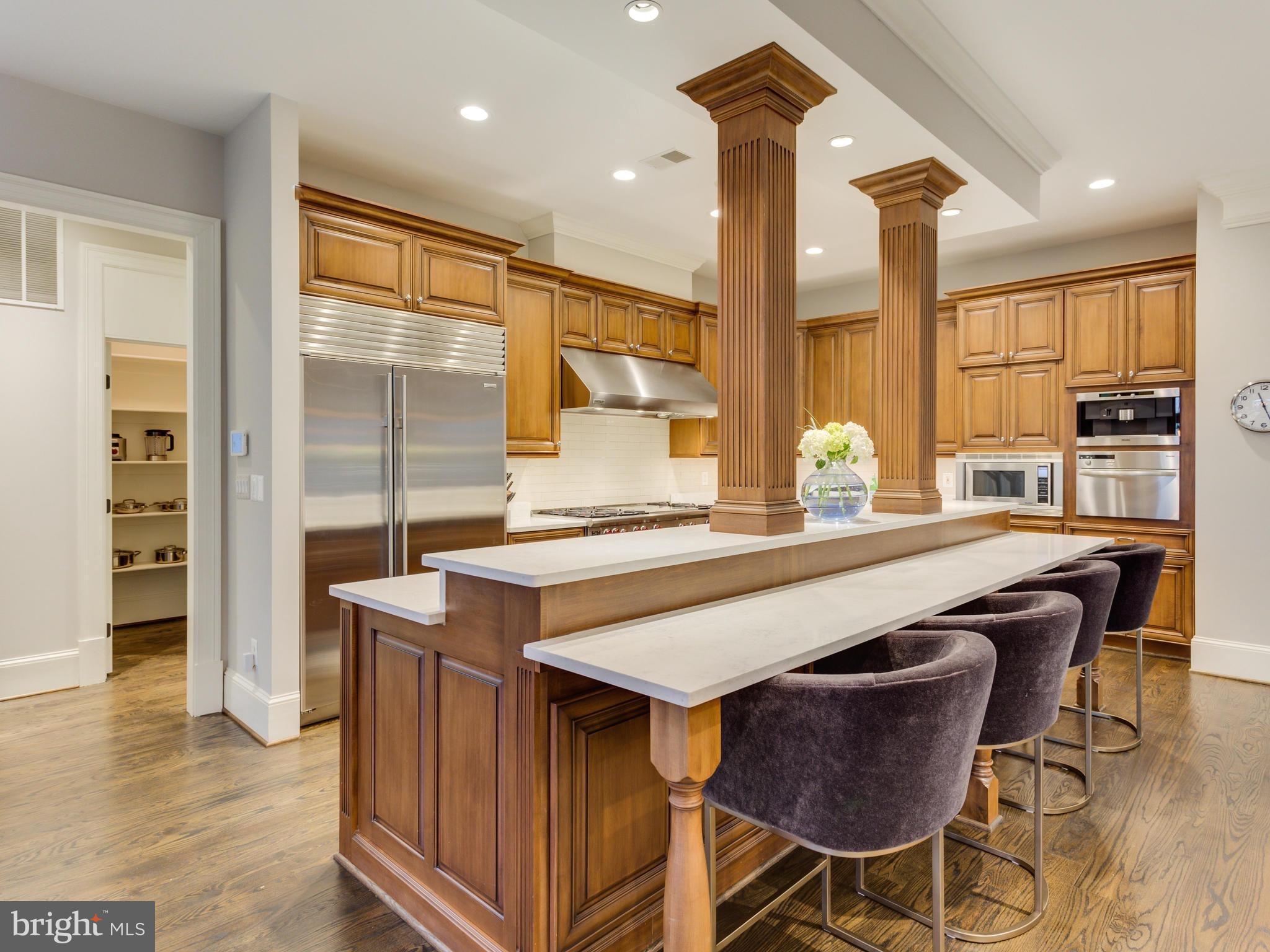 6906 Chelsea Road McLean, VA 22101 - Photo 10 of 25 a dining hall with stainless steel appliances granite countertop a table chairs and a refrigerator