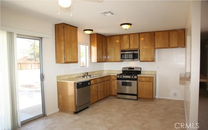 21110 Sandia Road Apple Valley, CA 92308 - Photo 3 of 3 a kitchen with stainless steel appliances granite countertop a stove and a refrigerator
