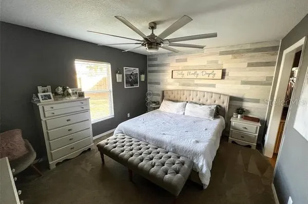 a spacious bedroom with a bed and a flat screen tv