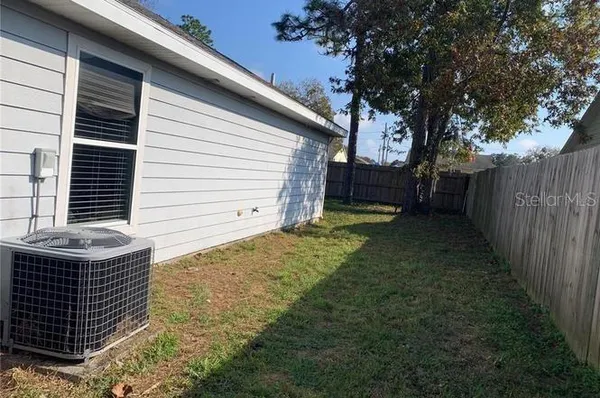 a view of backyard with wooden fence