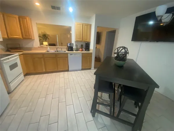 a living room with a flat screen tv a rug and a large mirror
