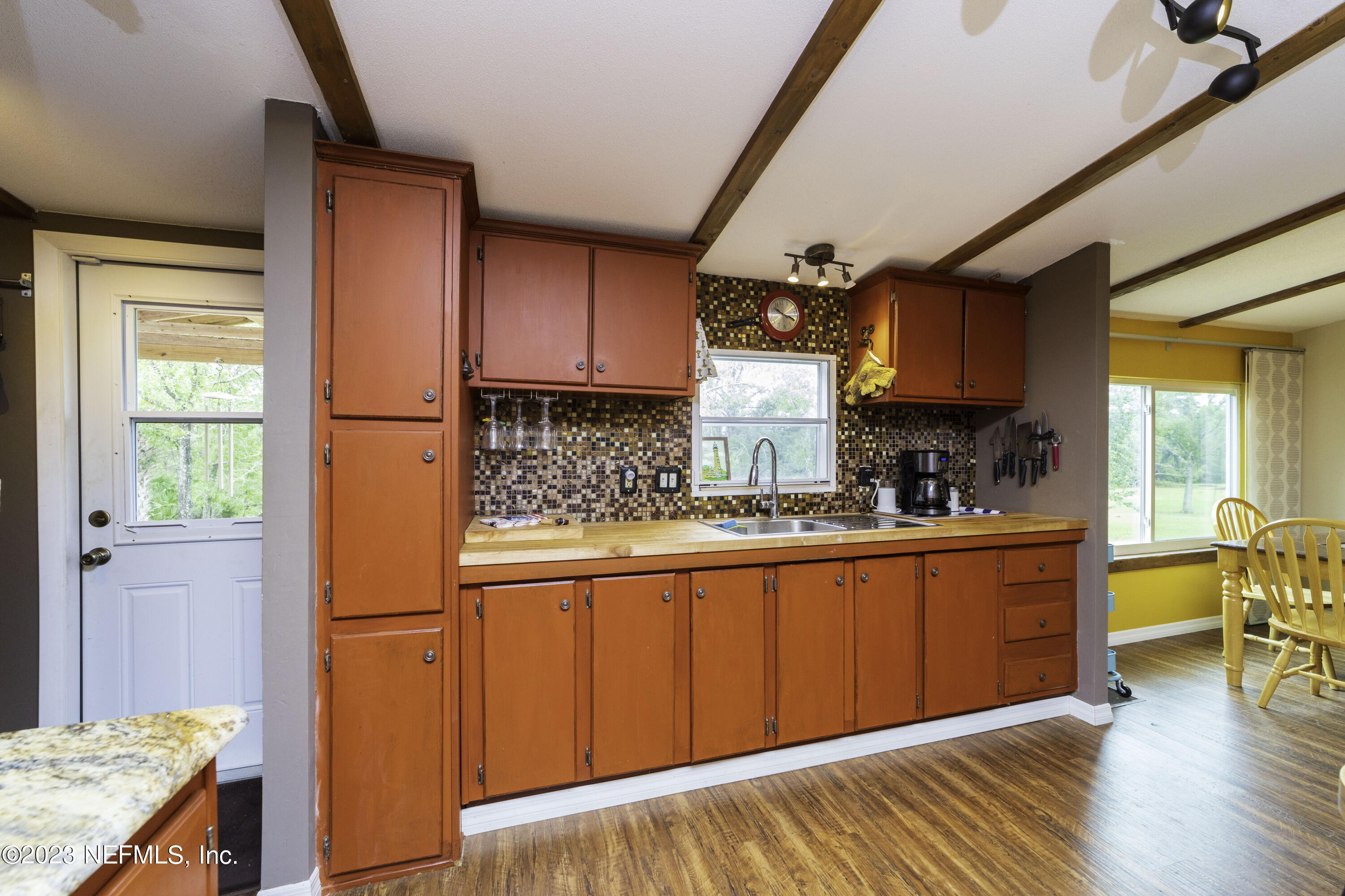 103 Long Branch Court Interlachen, FL 32148 - Photo 22 of 54 a kitchen with stainless steel appliances granite countertop a refrigerator a sink dishwasher a stove and a dining table with wooden floor