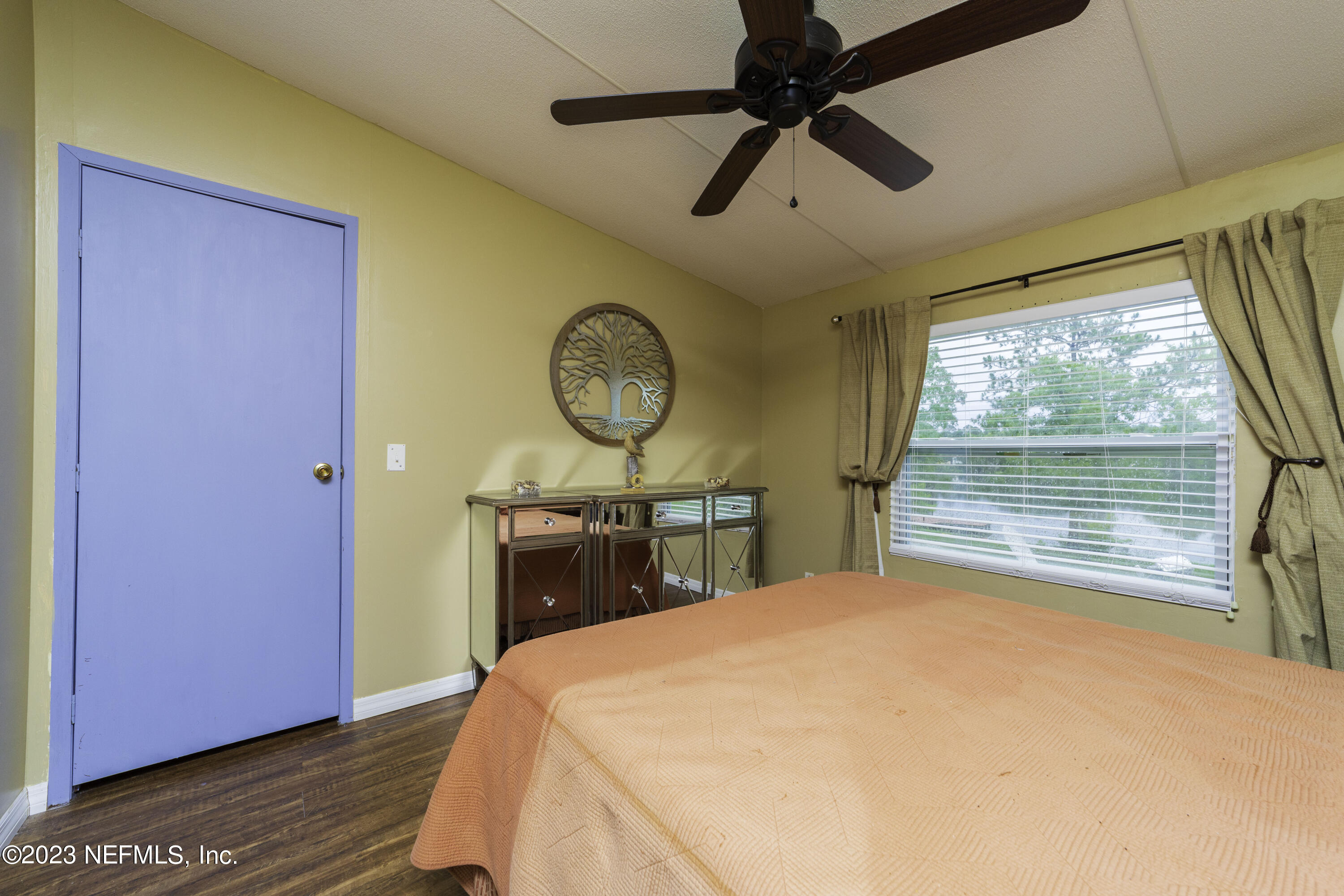 103 Long Branch Court Interlachen, FL 32148 - Photo 40 of 54 a bedroom with a bed a window and a chandelier